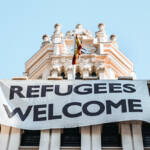 banner on white building with the slogan "Refugees welcome"