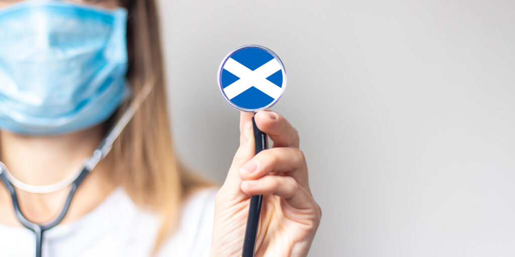 Doctor holding stethoscope with the Scottish flag on it.