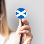 Doctor holding stethoscope with the Scottish flag on it.